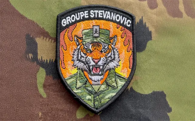 Zugbadge ricamato "GROUPE STEVANOVIC" con testa di tigre in uniforme davanti alle fiamme, patch militare in stile svizzero.